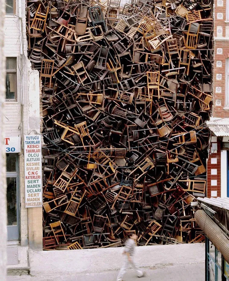 1550 Chairs Stacked Between Two City Buildings 2
